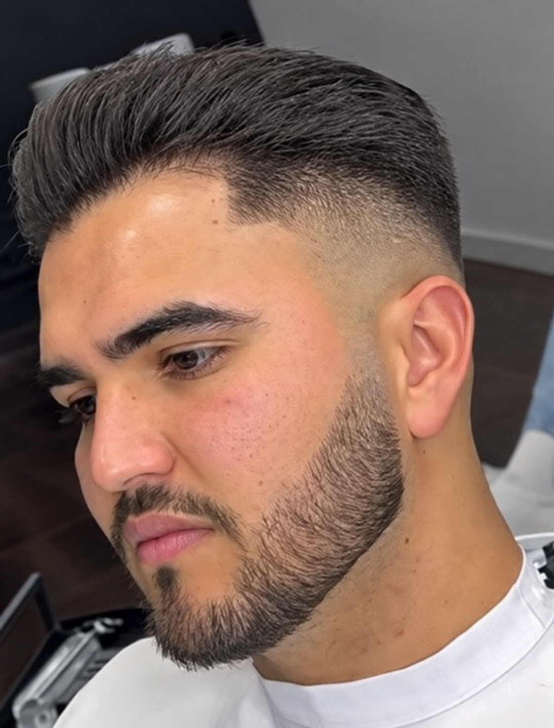 Corte penteado para trás com degradé e barba